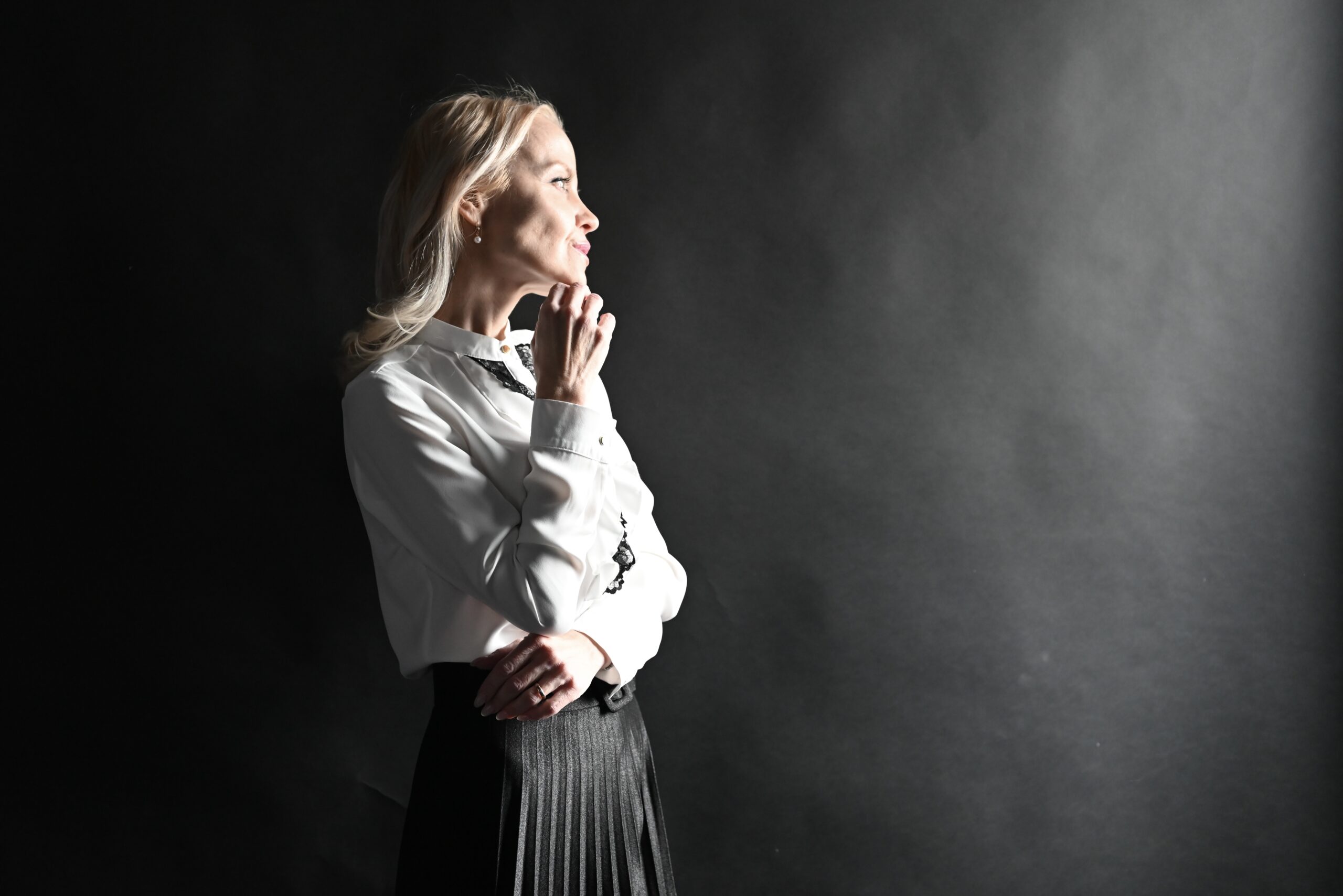 Naine valge pluusi ja musta seelikuga